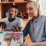 African American man and Caucasian woman collaborating on a project in a modern office setting.