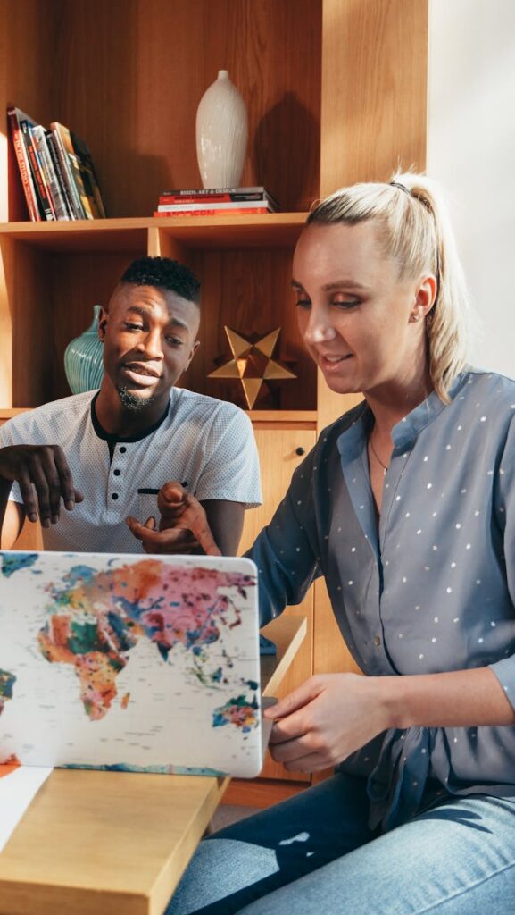 African American man and Caucasian woman collaborating on a project in a modern office setting.